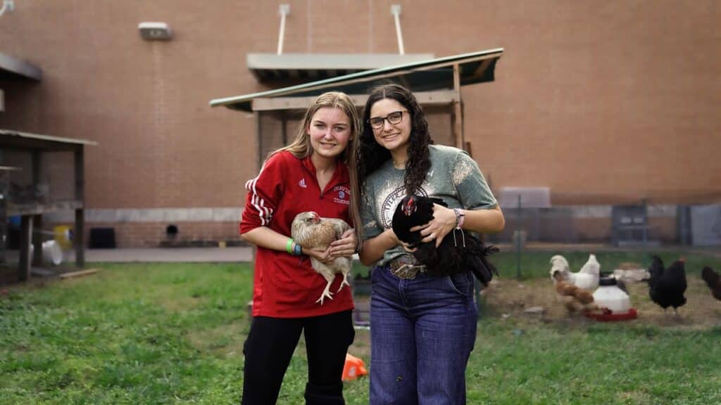 Students posing with chickens.