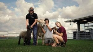 Group of student posing with a cow.