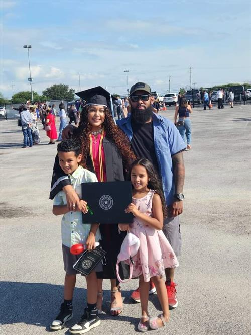 Ms. Diaz in graduation regalia with her family