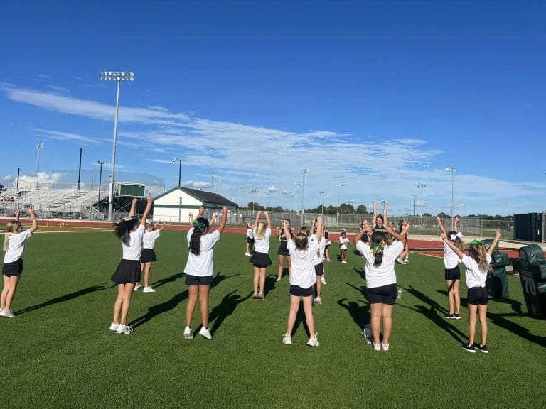High School cheerleaders coaching youth cheerleaders
