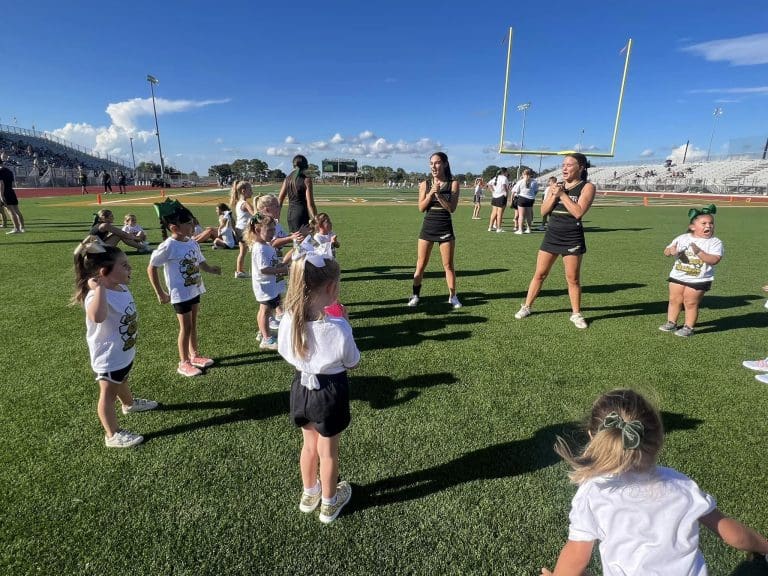 High school cheerleaders leading small groups