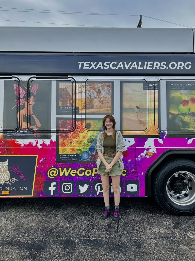 Winner poses in front of art bus