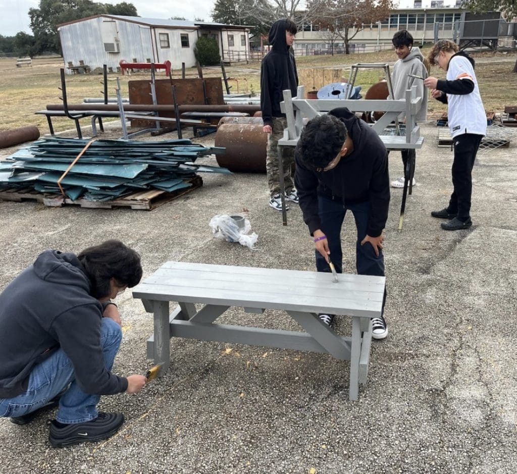 ECHS construction Students painting benches