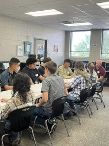 Huffman ISD graphic design students listen and take notes