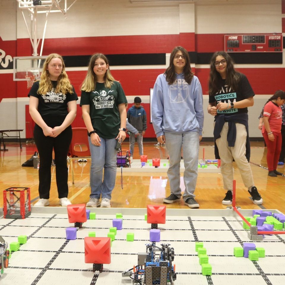 robotics students watch their robots take on challenges