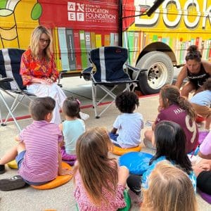 Children gathered around a woman speaking