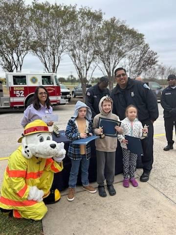 Fort Sam Houston ISD students pose with firemen and mascot.