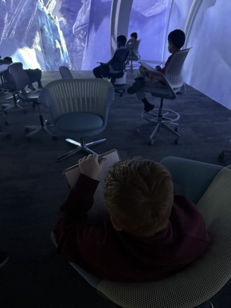 Forney ISD student studying and taking notes of presentation